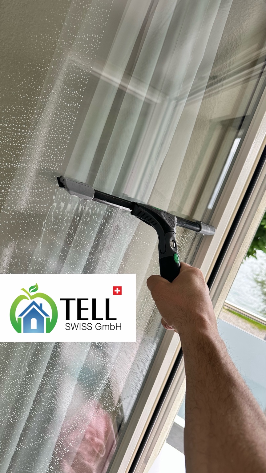Tell Swiss beim Reinigen eines Fensters mit einem Fensterabzieher